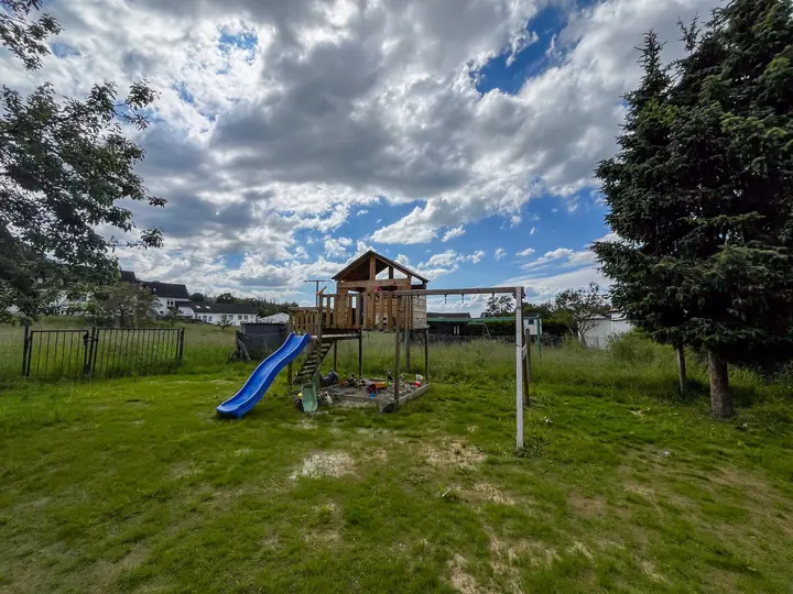 Garten mit Spielturm, Rutsche und Schaukeln